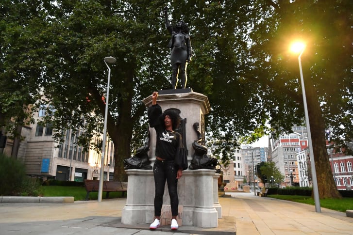 Jen Reid poses by a statue of a Black Lives Matter protestor in Bristol, England. Credit: CNN and Matthew Horwood/Getty Images